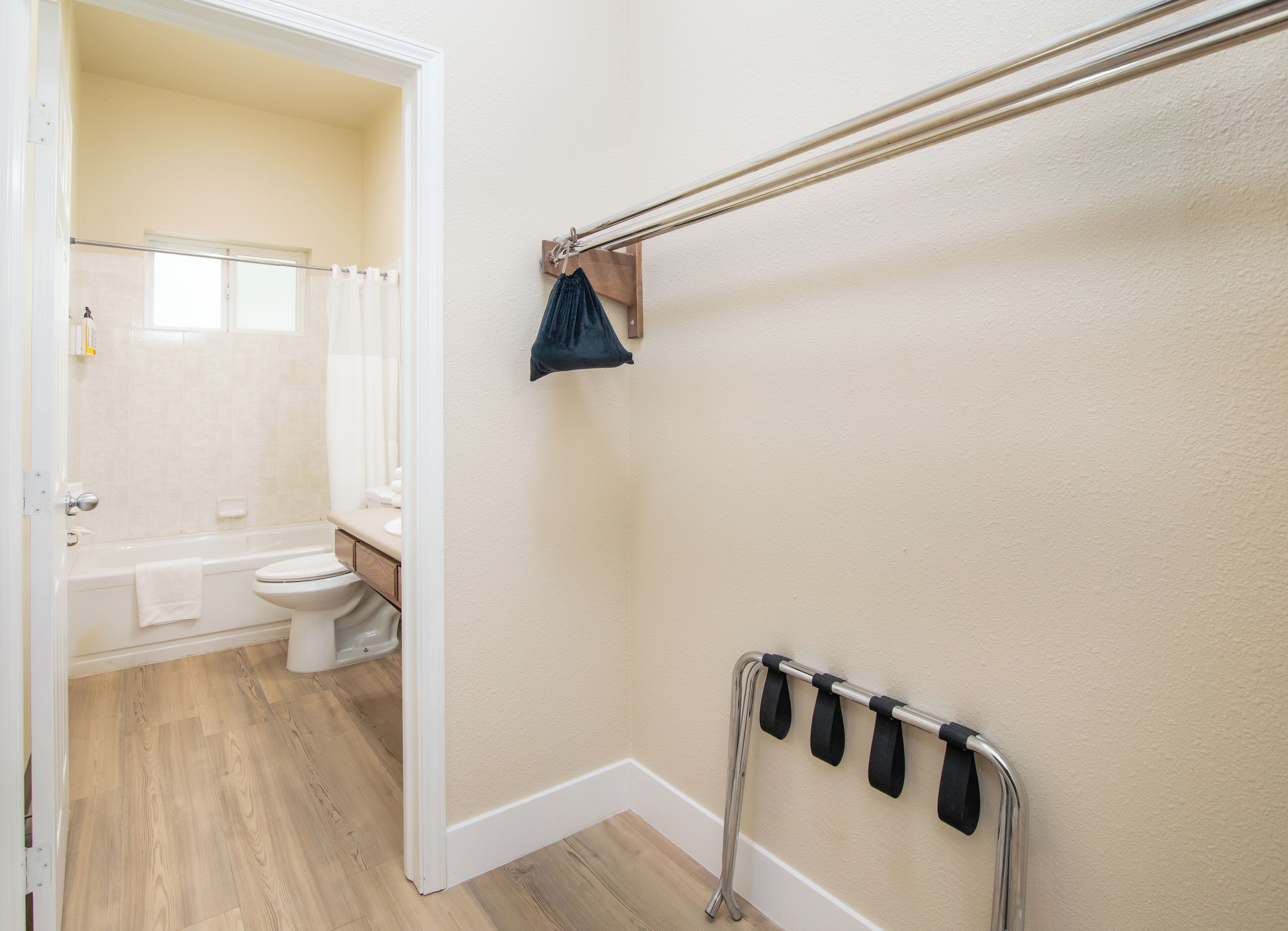 Un baño con bañera, inodoro y barra para toallas.