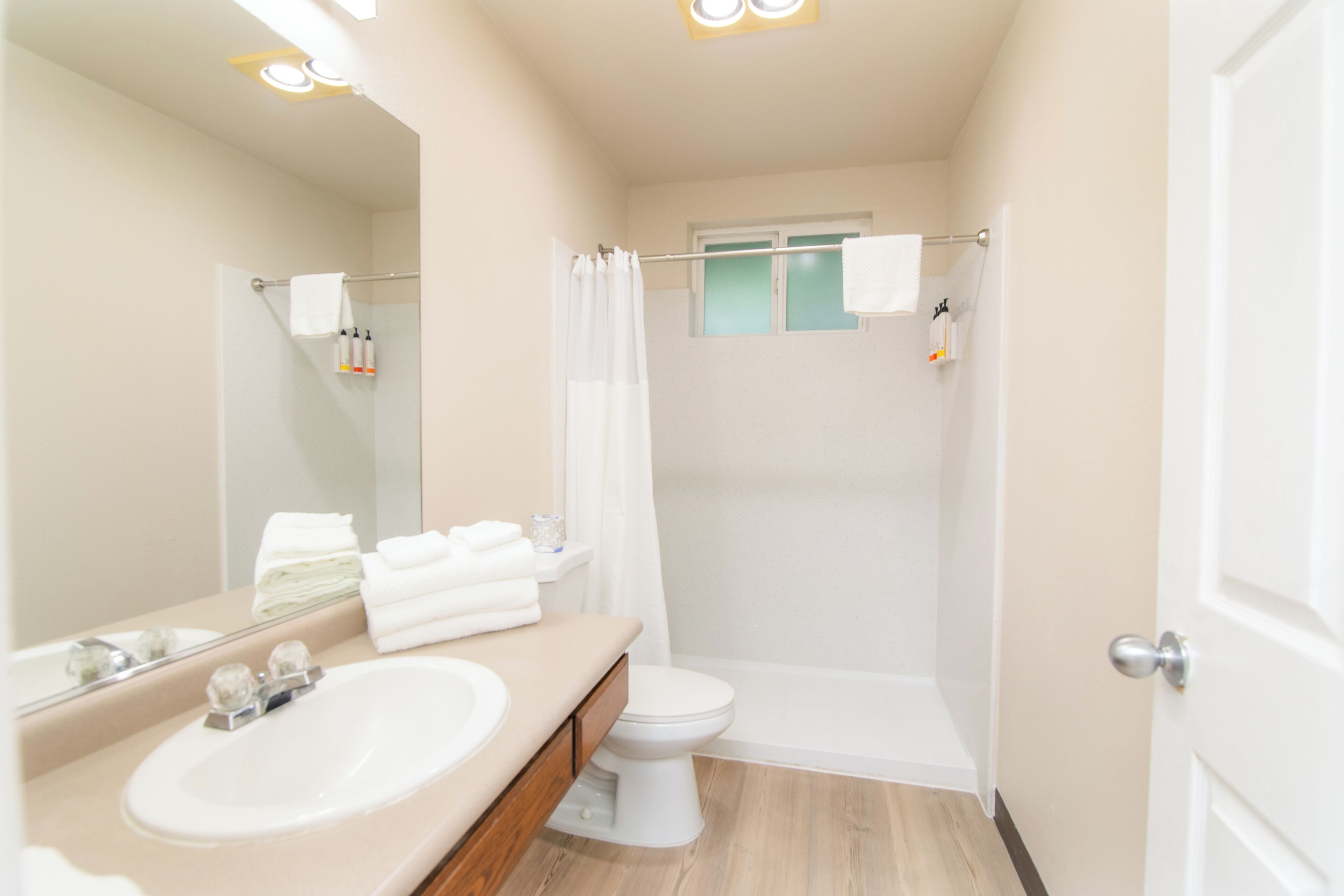 A modern bathroom with a sink, toilet, and shower.