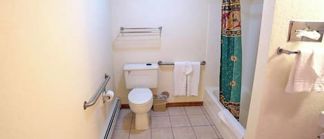 Un baño pequeño con inodoro, cortina de ducha y toallero.
