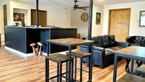 A modern interior with a bar area, seating, and a ceiling fan. - Big Horn Lodge (Grand Lake)