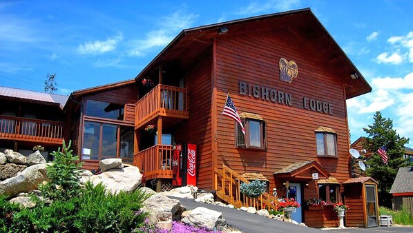 Experience the charm of Bighorn Lodge, featuring a balcony with a railing and a Coca-Cola sign.