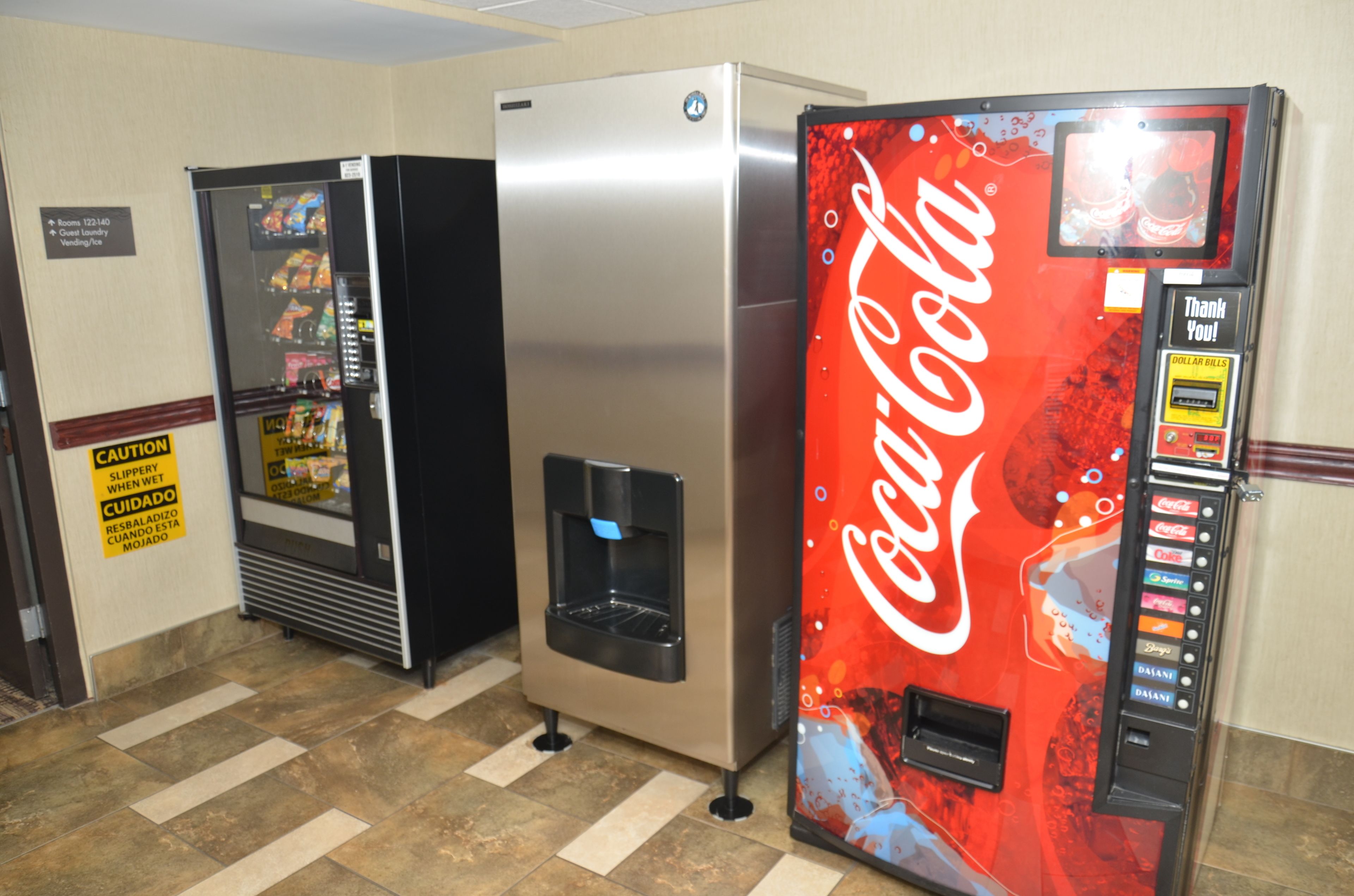 A vending area with a Coca-Cola machine and a refrigerator vending machine.