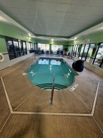 Una piscina techada, sillones reclinables de piscina