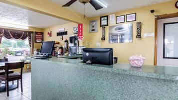A reception area with a computer, a coffee machine, and a sign indicating a manager on duty.