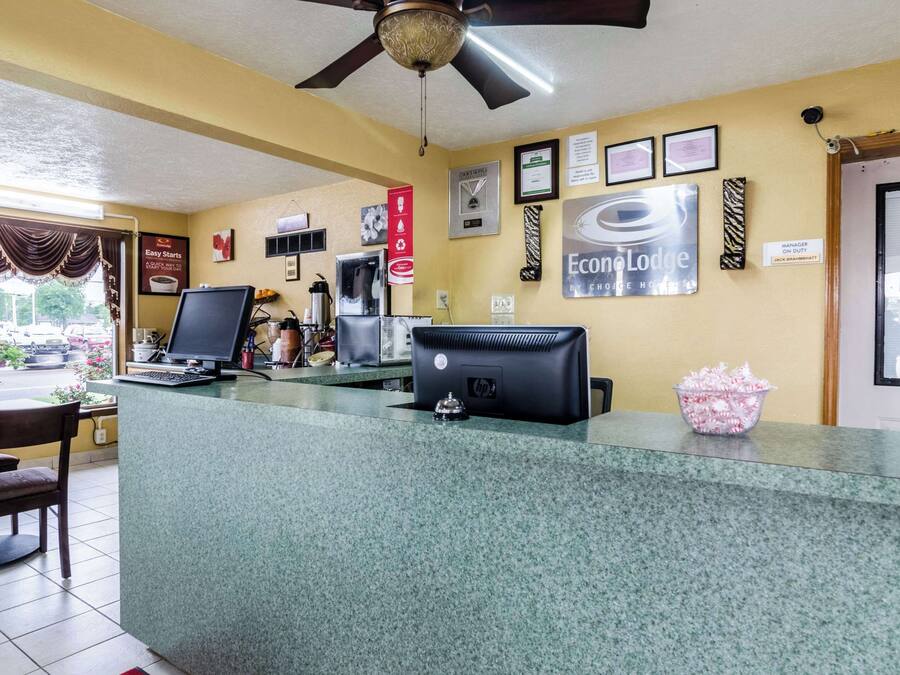 A reception area with a computer, a coffee machine, and a sign indicating a manager on duty.
