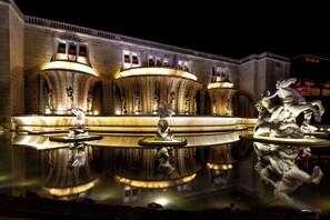 A nighttime view of a grand building with a reflective water fountain in front. - Hotel AS Lisboa (Lisbon)