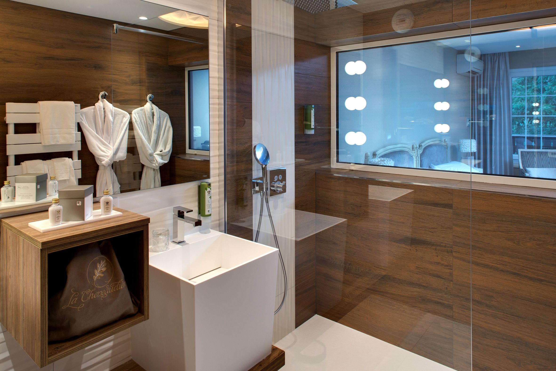 Un baño moderno con un espejo grande, tocador y zona de ducha.