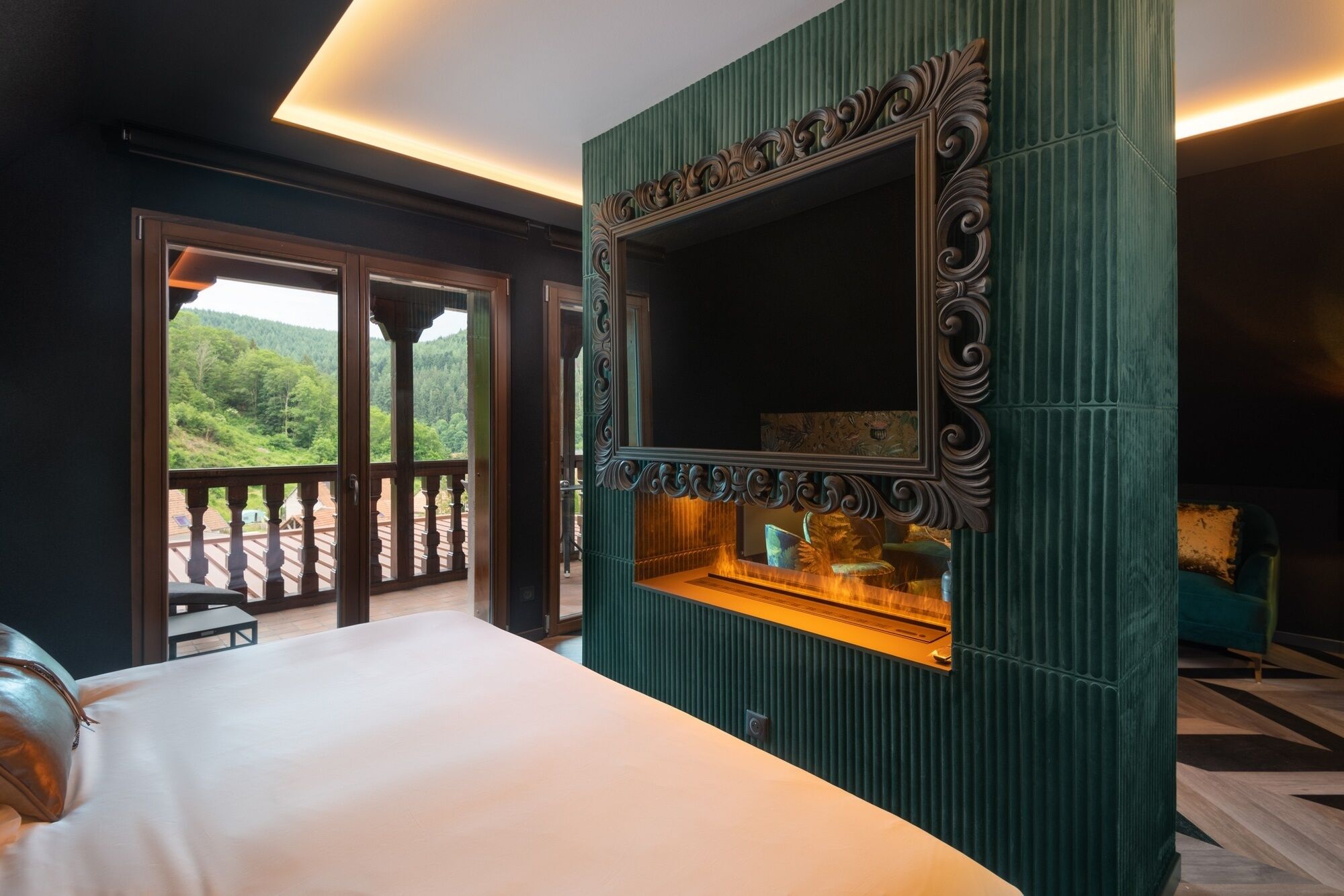 Un dormitorio con una cama grande, un espejo decorativo y vistas a un balcón con barandilla.