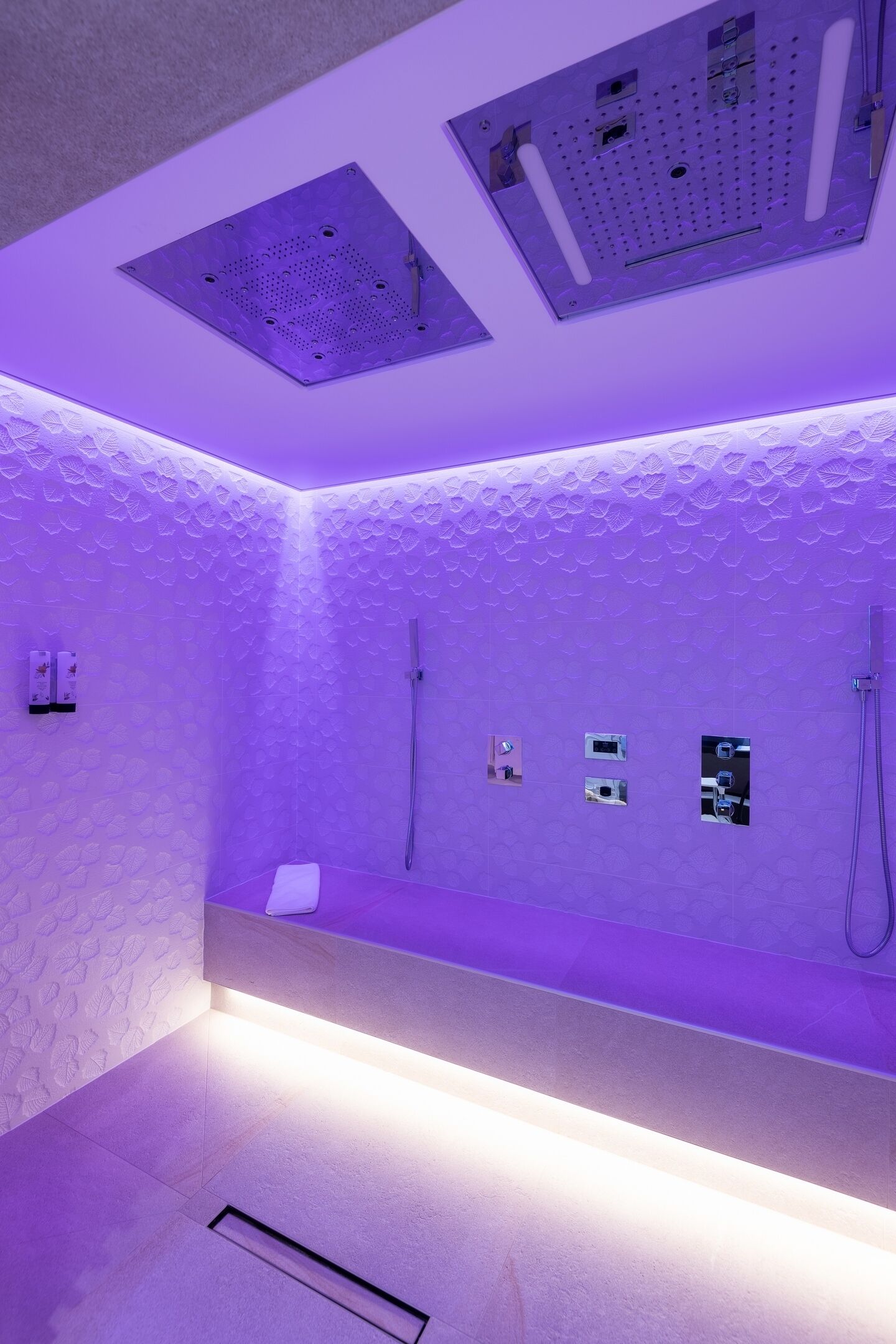 A bathroom with a shower, a towel rack, and a ventilation system.