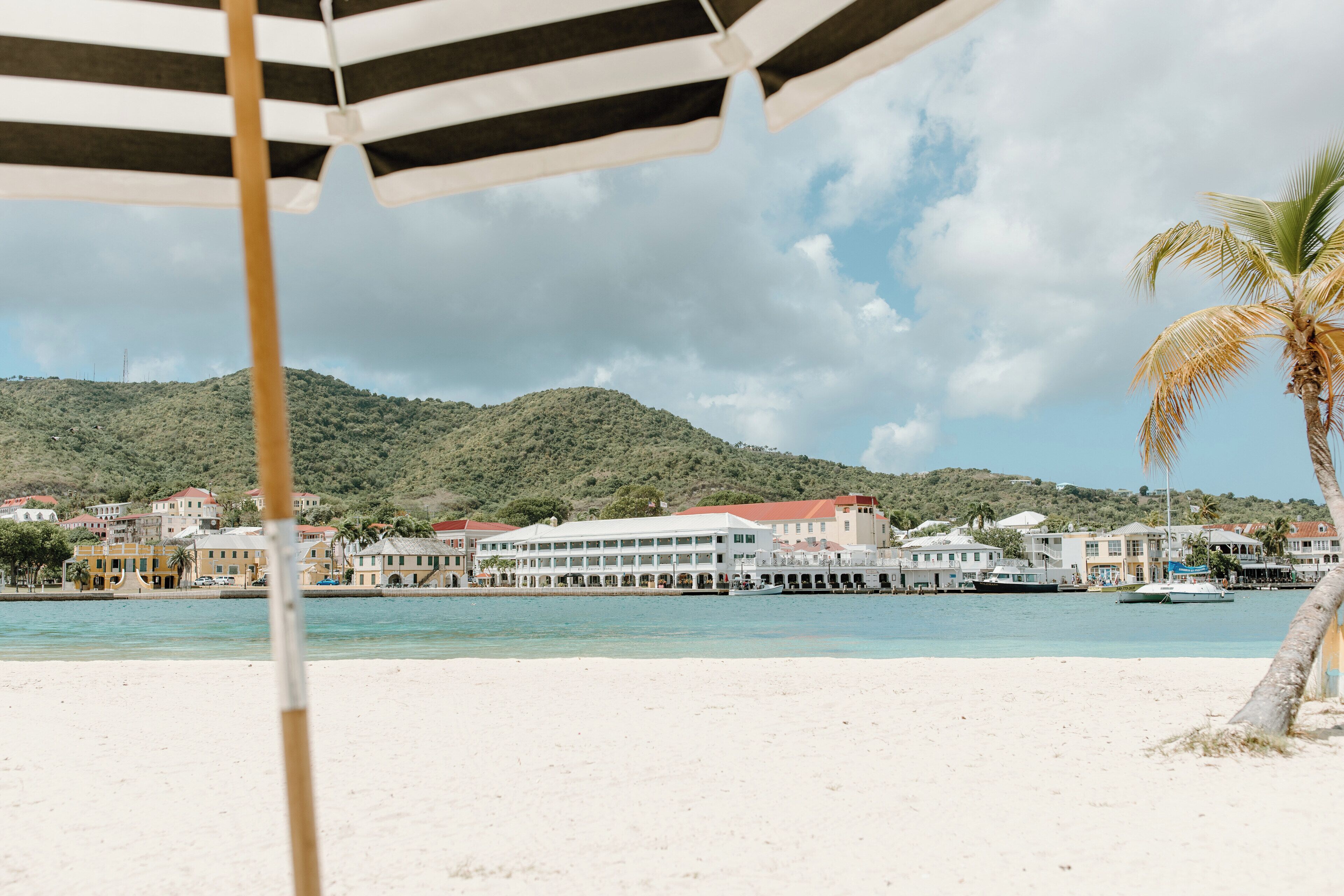 A beach with a view of buildings and a pier.