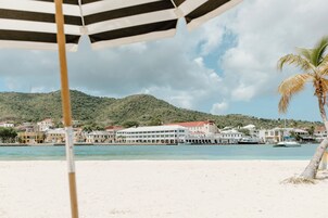 A beach with a view of buildings and a pier.
