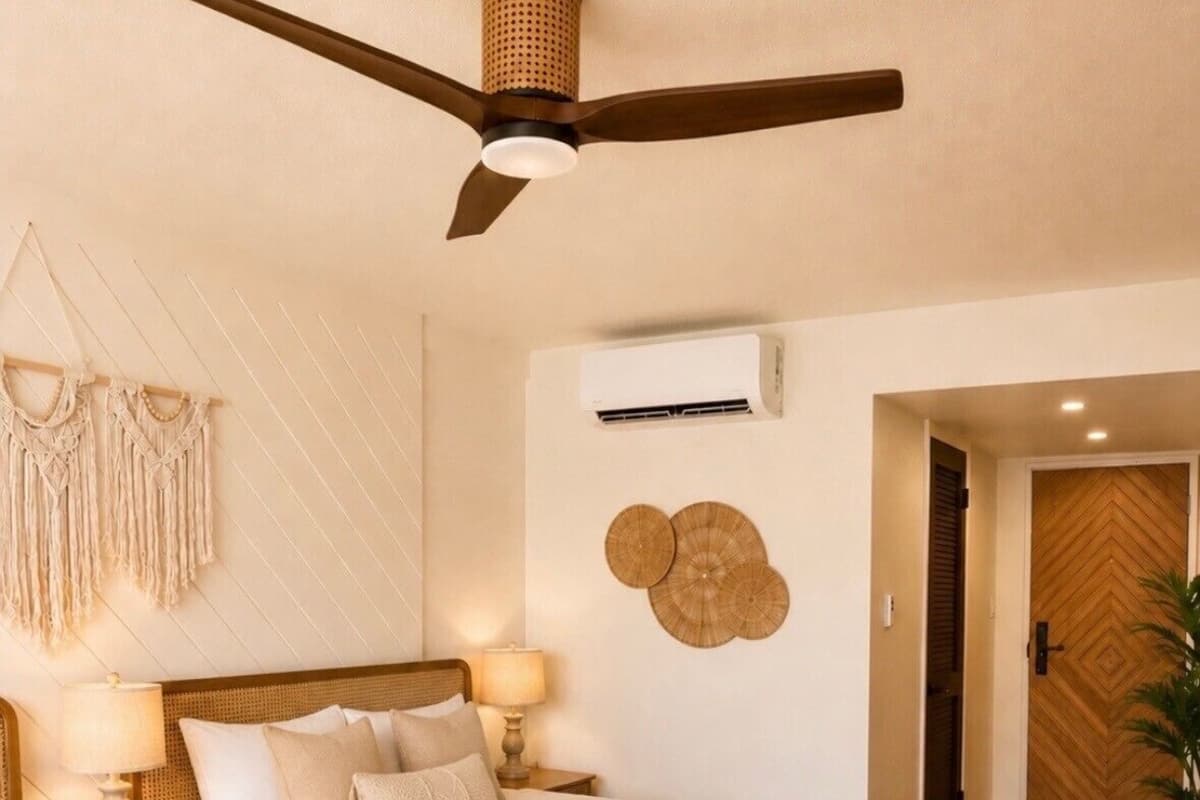 A hotel room with two beds, a ceiling fan, an air conditioning unit, macrame wall decor, and a wooden door.