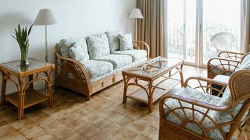 Suite superior, varias camas, vista al océano | Área de sala de estar | Televisión de pantalla plana