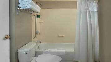 A bathroom with a toilet, bathtub, and shower curtain.
