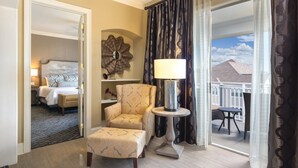 A hotel room with a bed, a chair, a table with a lamp, a decorative mirror, and a view of the outside. - Club Wyndham Nashville (Nashville)