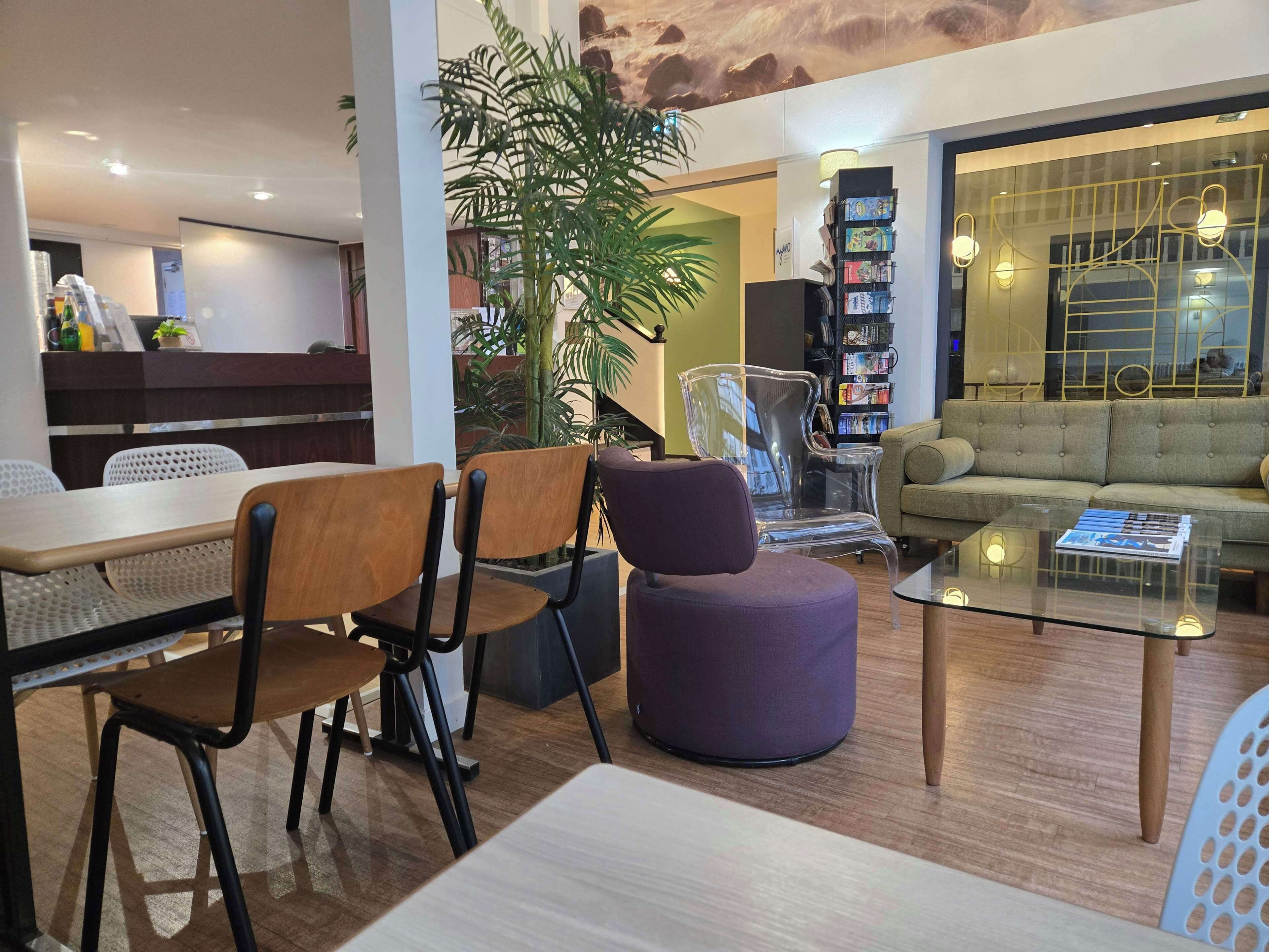 Un interior moderno con comedor, asientos, una estantería y un sofá.