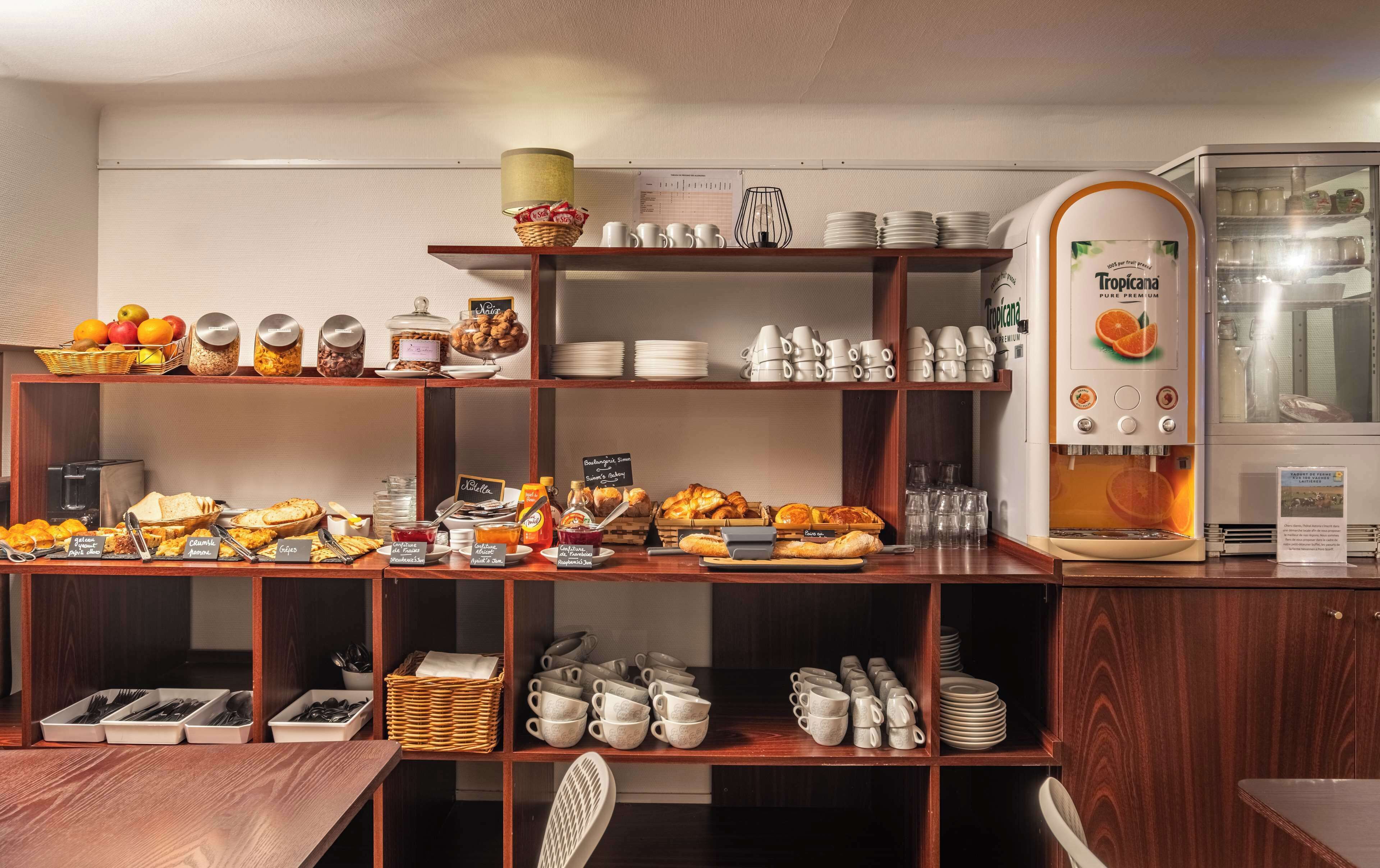 Un buffet per la colazione con diversi cibi, posate e una macchina per il caffè.