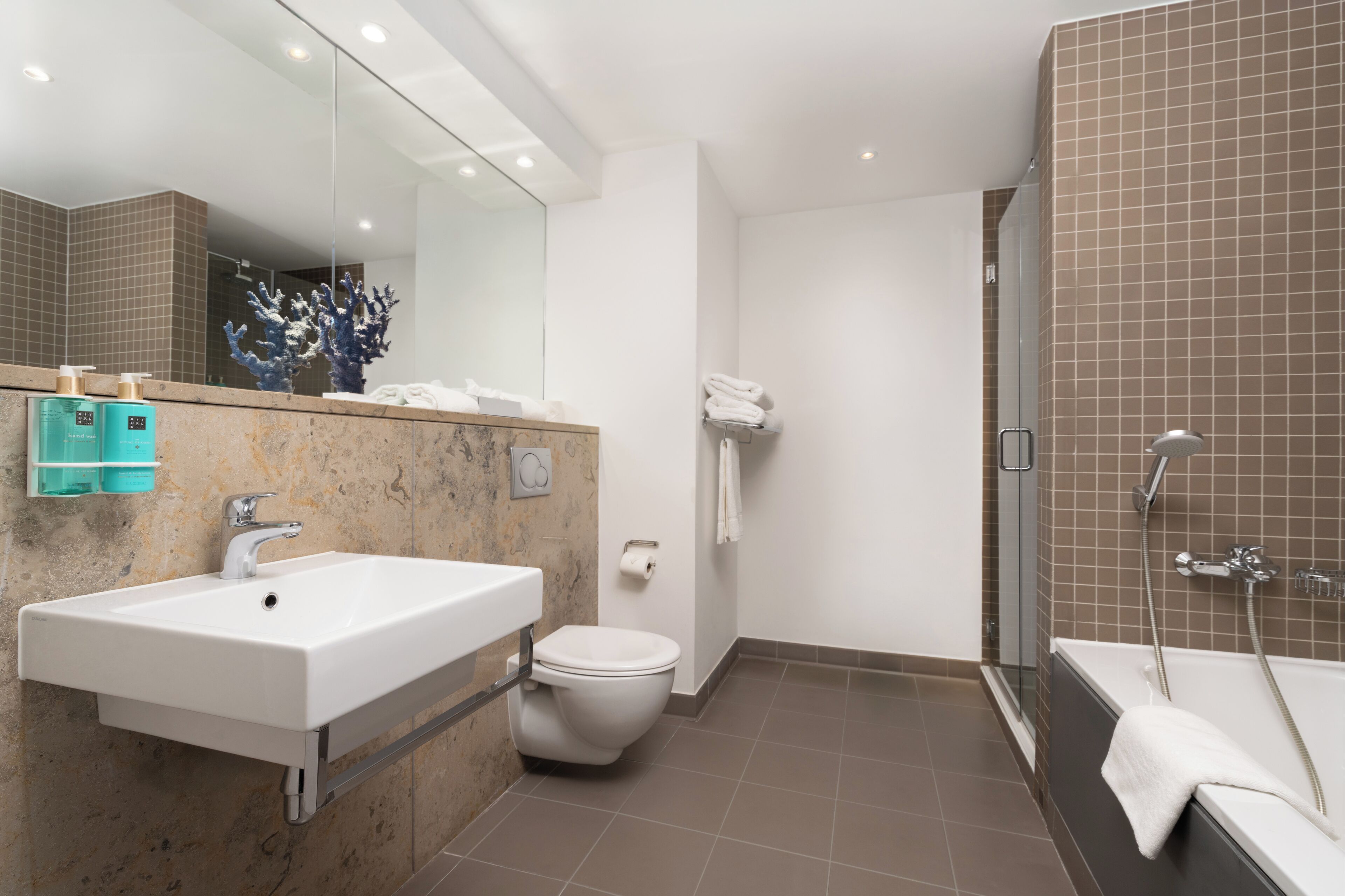 A modern bathroom with a white sink, toilet, and bathtub.