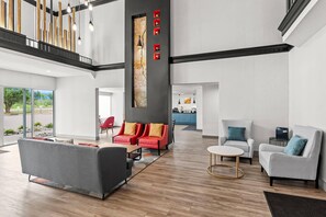 A spacious lobby with a high ceiling, a staircase, and a view of the outdoors.