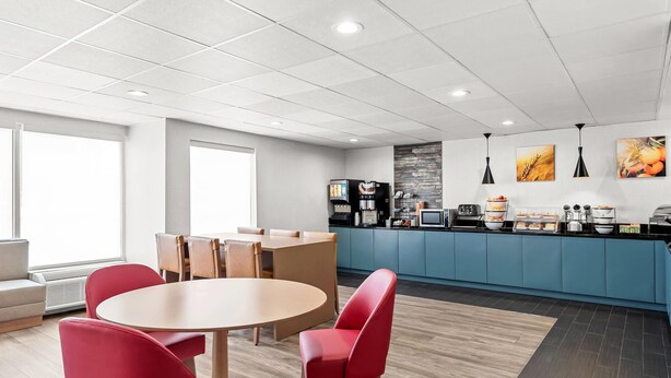 A modern hotel room with a dining area, a kitchenette, and a large window providing natural light. - Comfort Inn Ruther Glen near Kings Dominion (Ruther Glen)