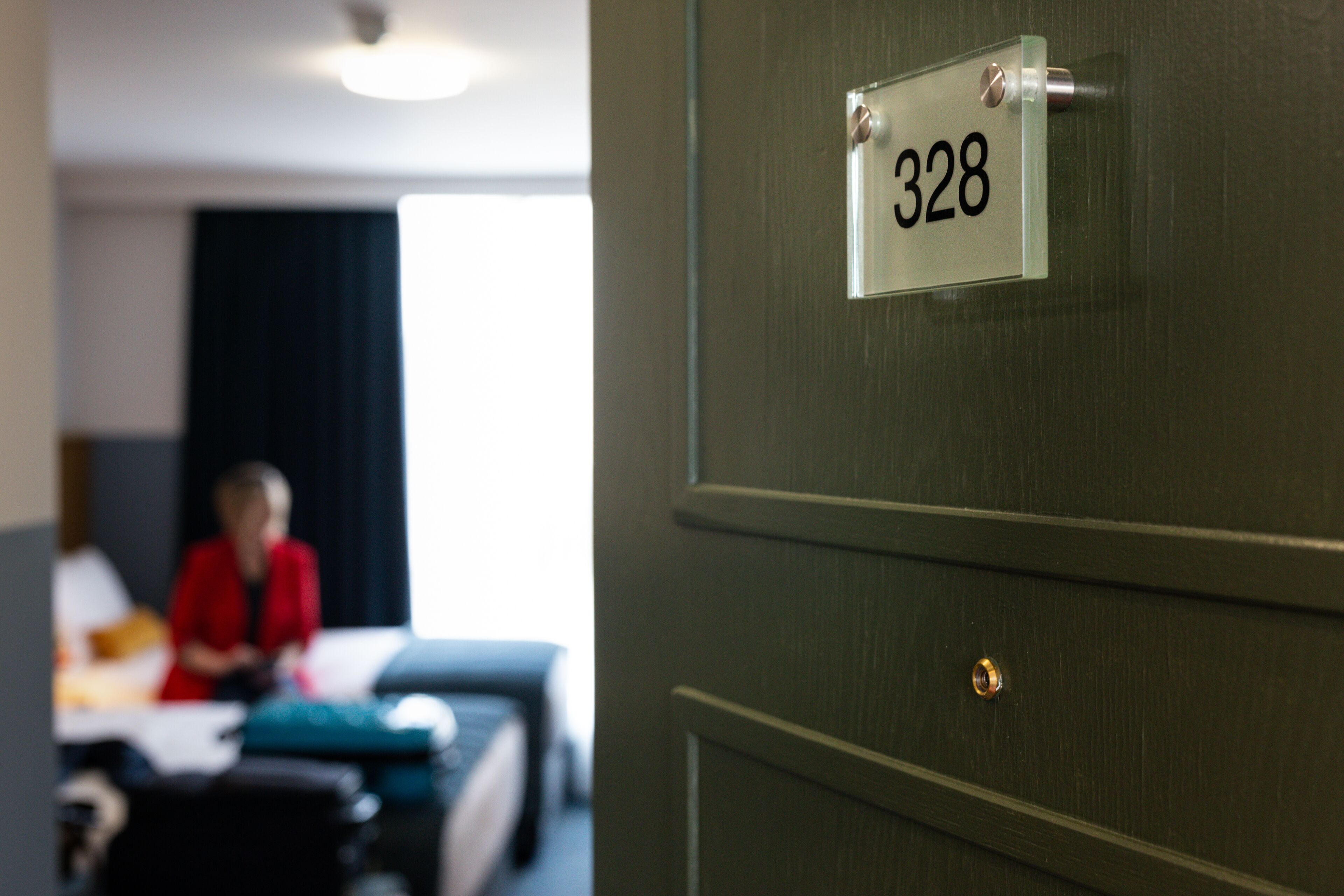 Een hotelkamerdeur met een bordje met het nummer 328.