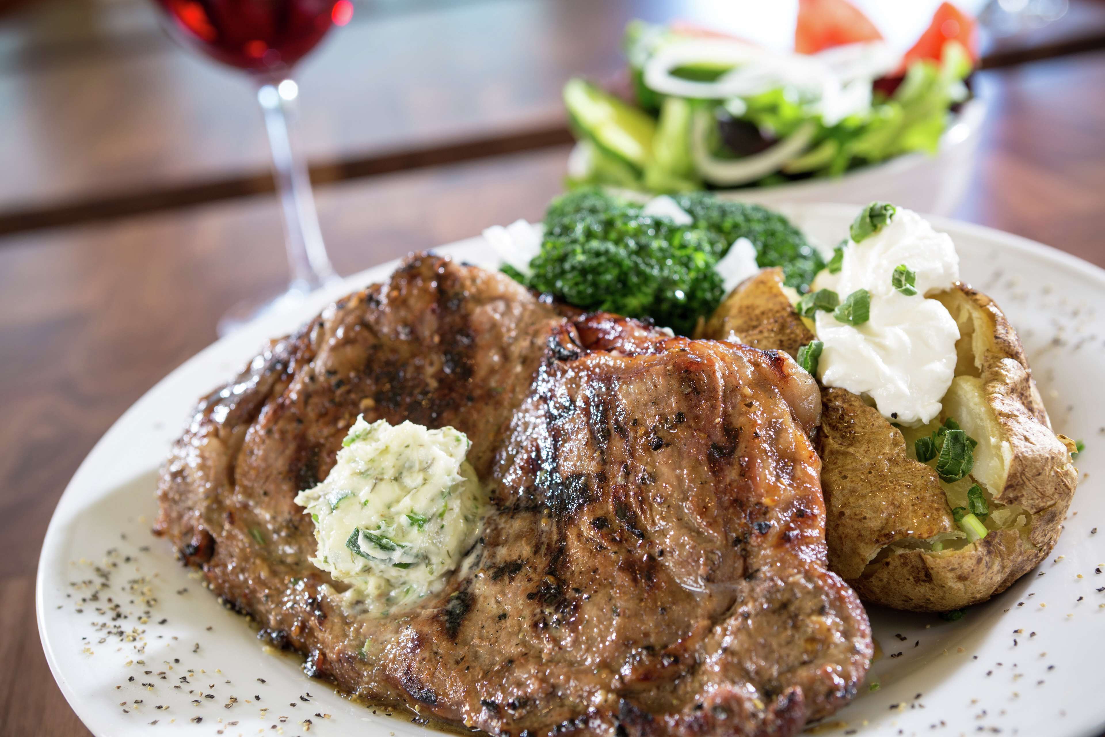 A plate with grilled steak, mashed potatoes, and a side salad.