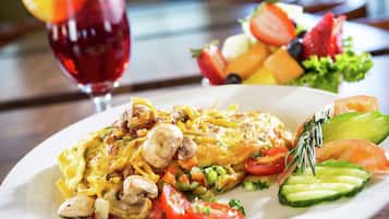 Un piatto di cibo con un'insalata e un bicchiere di bevanda rossa.