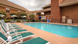 Una piscina al aire libre de temporada, tumbonas