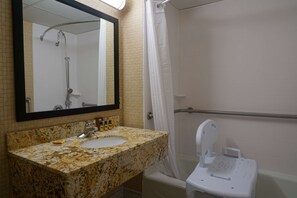 A bathroom with a granite countertop sink, a mirror, a shower with a handheld showerhead, and a white toilet with a bidet attachment. - Best Western Plus Morristown Conference Center Hotel (Morristown)
