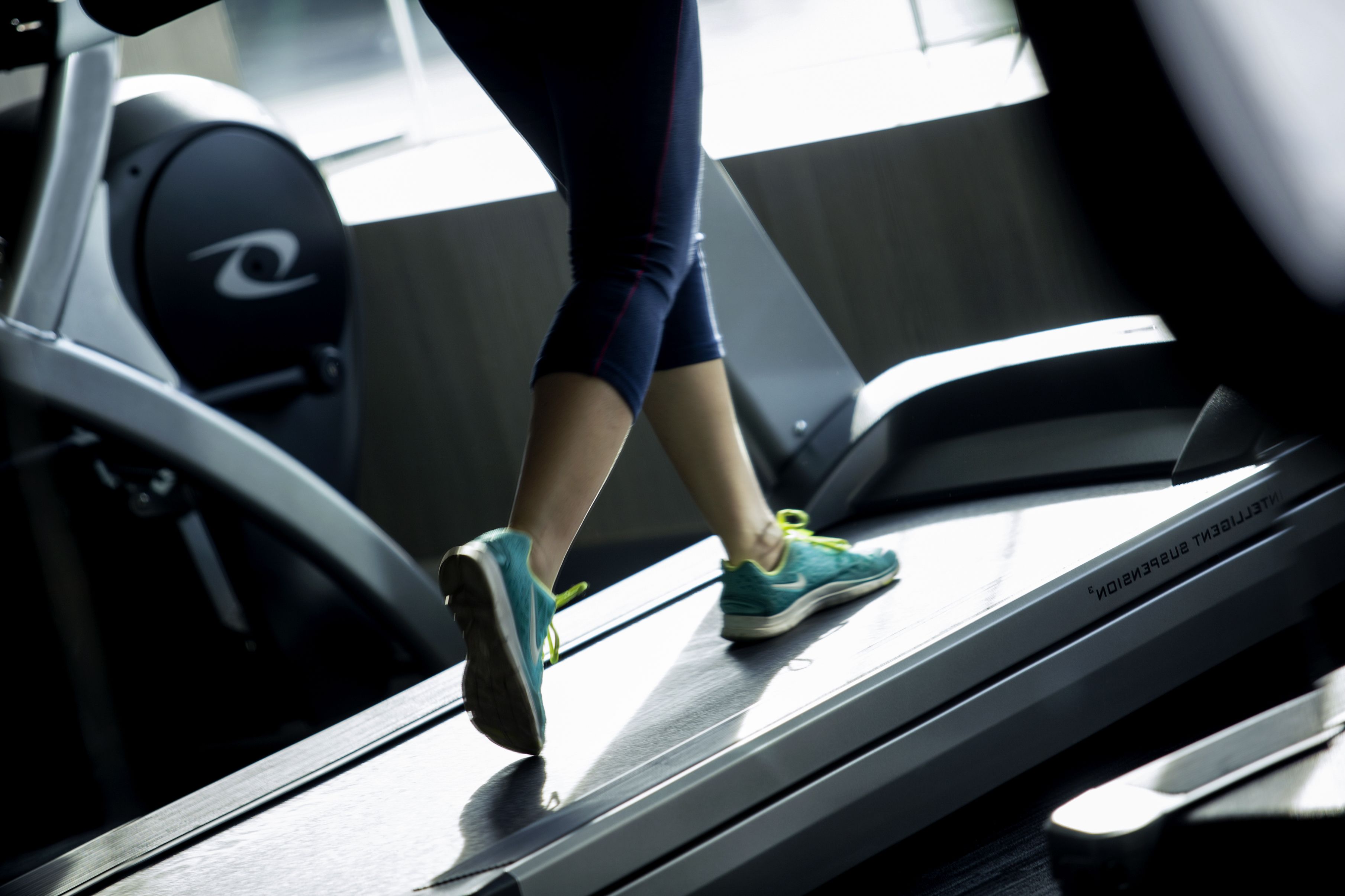 Una persona corriendo en una cinta de correr en un gimnasio.