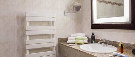 A bathroom with a white towel rack, a sink with toiletries, and a mirror.