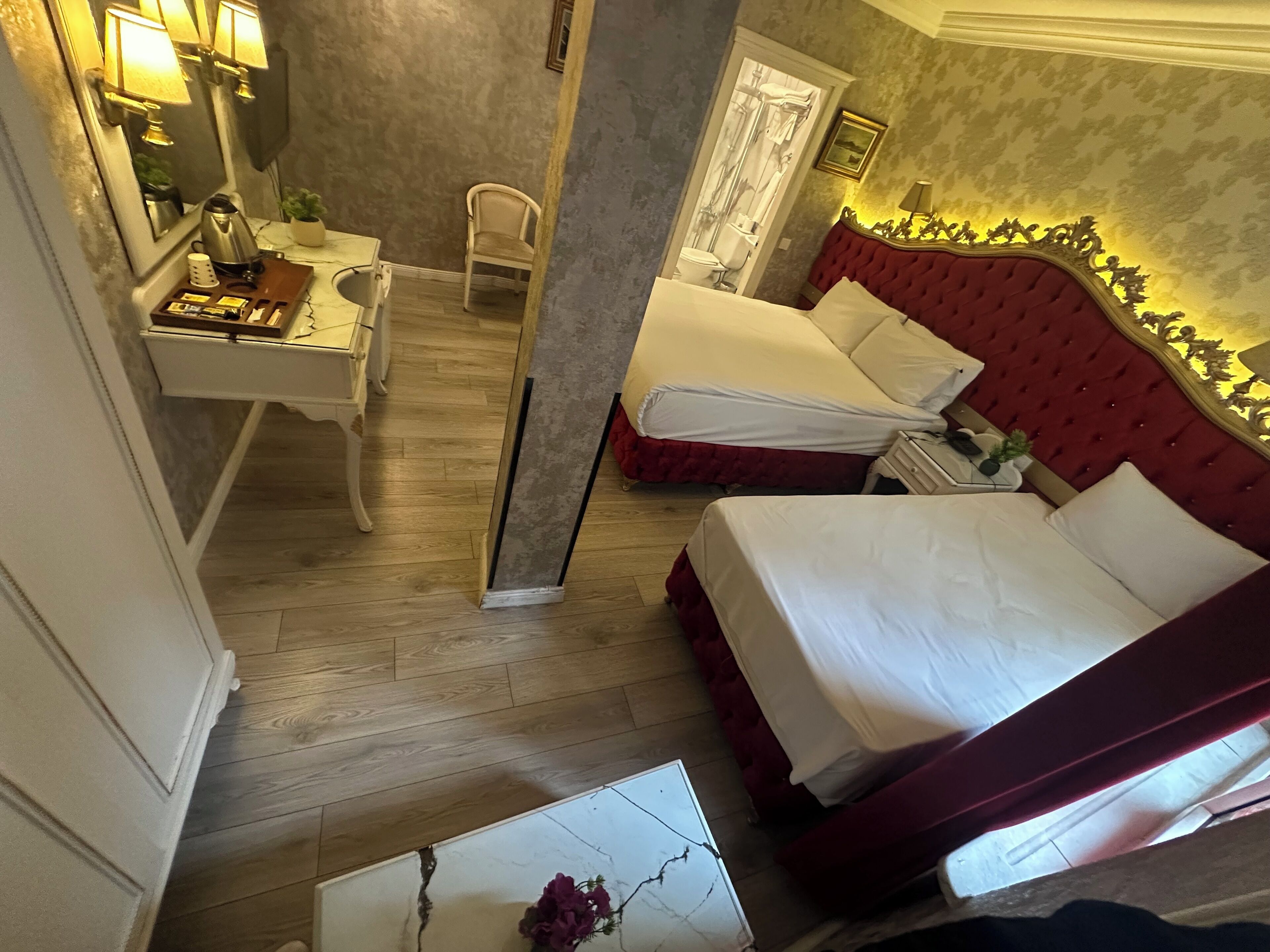 A hotel room with two beds, a desk, and a chair.