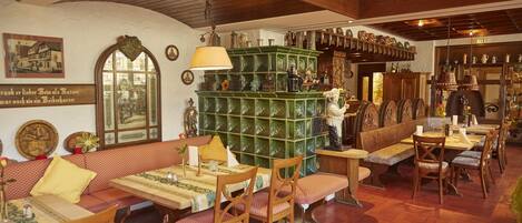 A traditional inn with wooden furniture, a green bar area, and various decorations.