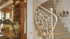 Una escalera con barandillas blancas adornadas y un cartel de 'Stuckist Café' al fondo.