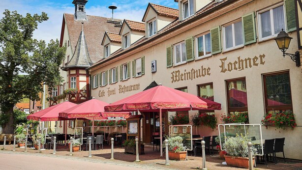 Un hotel con terraza exterior, un letrero que dice 'Heinrich Lochners' y un estilo arquitectónico tradicional europeo.