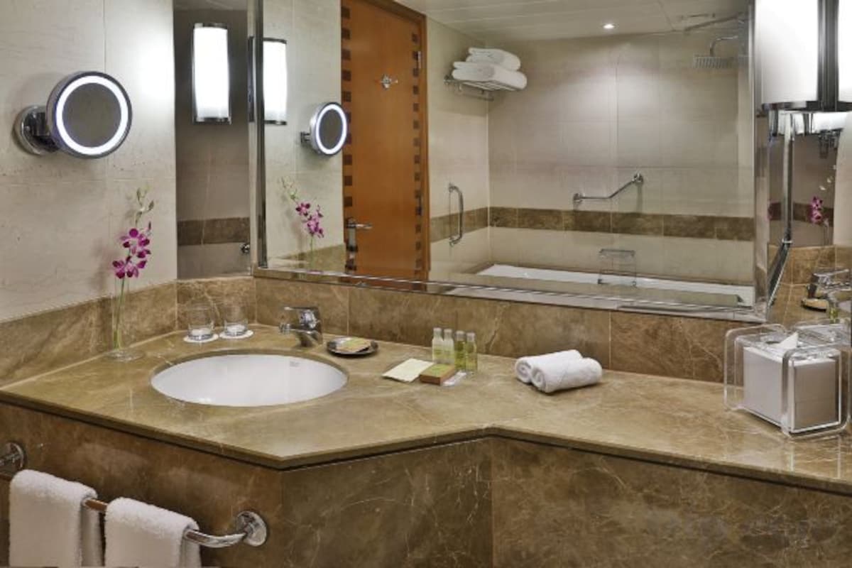Un baño con lavamanos doble, un espejo grande y una cabina de ducha con paredes de vidrio.
