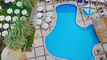 Relax by the uniquely shaped pool surrounded by comfortable seating options and a clean walkway.