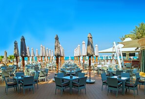 A beachside restaurant with outdoor seating and umbrellas. - Hilton Dubai Jumeirah (Dubai)