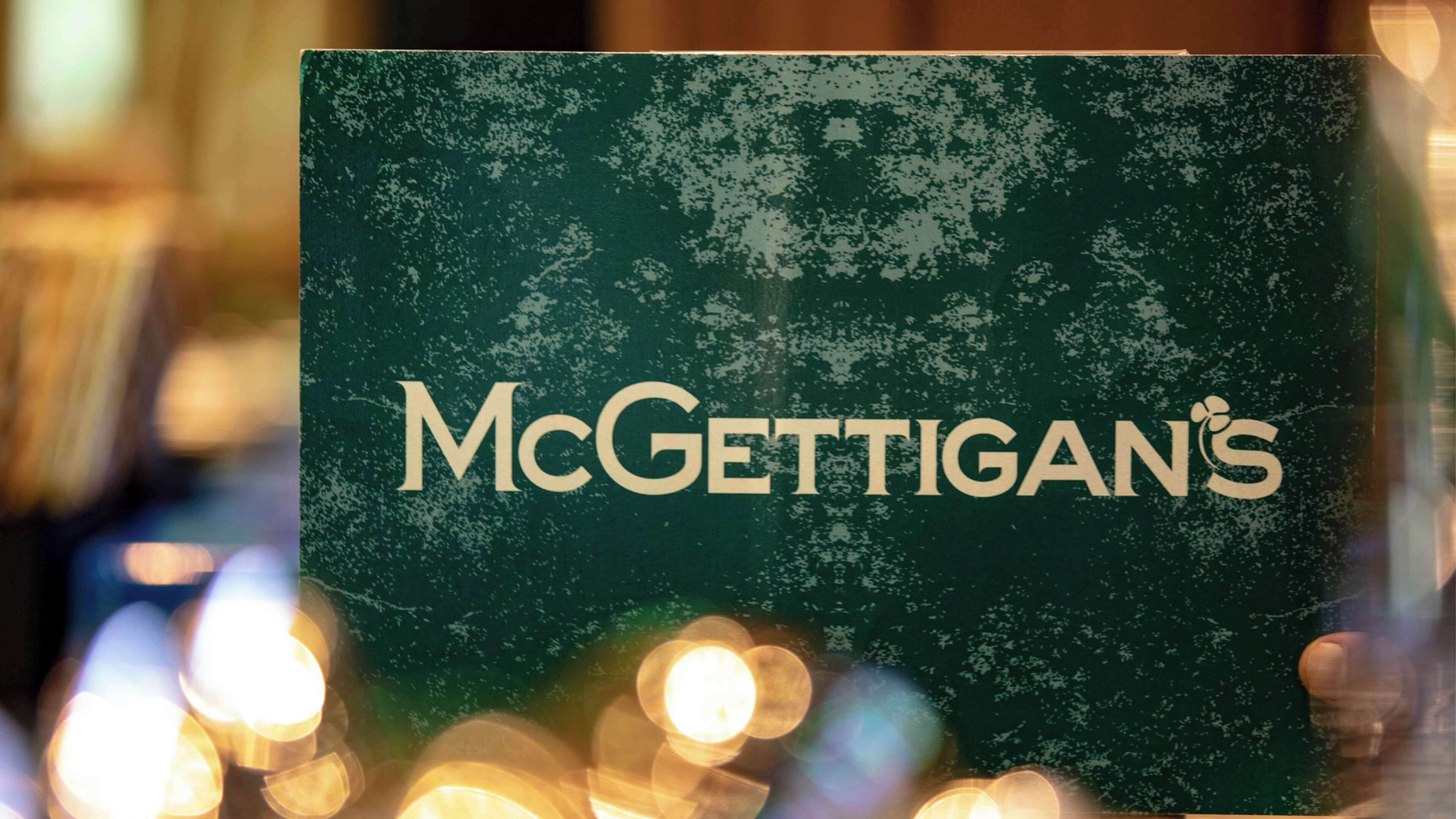 Ein Schild von McGettigan's mit einem verwitterten, grünen Hintergrund und einem Schneemuster.