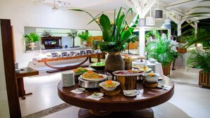 Un buffet proposant une variété de plats et agrémenté d’une plante décorative placée au centre.