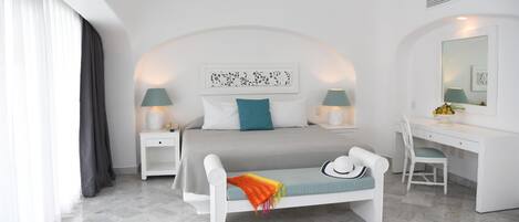 Una habitación de hotel moderna con cama, mesitas de noche, escritorio y una silla.