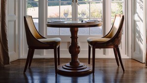 A room with a large window, two chairs, a table, and a patterned rug. - Dunbrody Country House Hotel (Arthurstown)