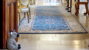 A grand hallway with a chandelier, a blue patterned rug, and classic furniture including a table and chairs. - Dunbrody Country House Hotel (Arthurstown)
