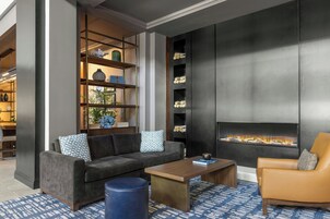 Una sala de estar moderna con sofá, sillón, mesa de centro y chimenea.