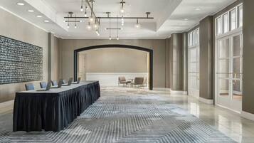 A conference room with a long table, chairs, and a patterned carpet.