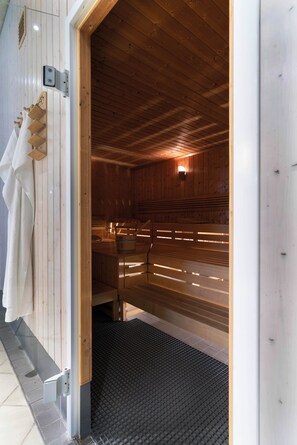 A sauna room with wooden benches and a tiled floor. - Seminaris Sunday See Hotel Potsdam (Potsdam)