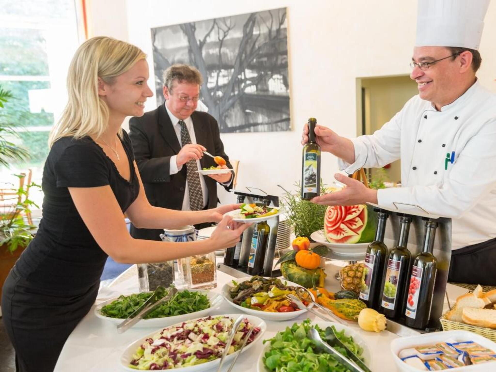 Ein reichhaltiges Buffet mit verschiedenen Speisen und einem Koch, der das Essen anbietet.