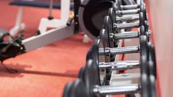 Una fila de equipo de levantamiento de pesas en un gimnasio.