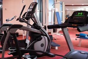 A gym with various exercise equipment, including treadmills and weight machines. - Seminaris Sunday See Hotel Potsdam (Potsdam)
