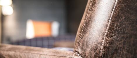 A close-up of a leather sofa with visible stitching and wear.